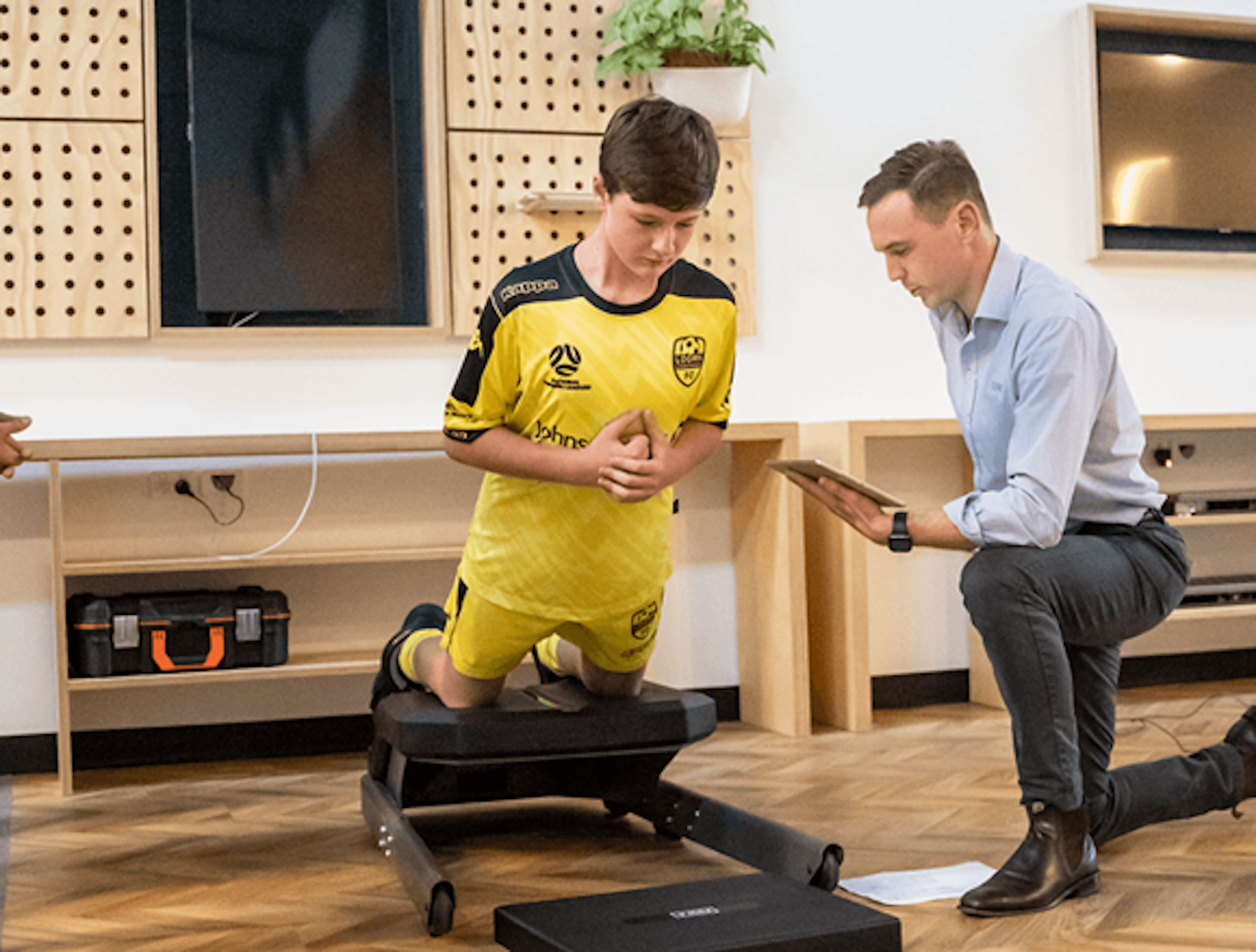 Physiotherapist Brad Moore conducting a Nordic test with an academy football player.